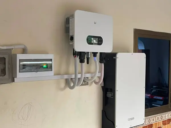 Hybrid inverter beside a tall lithium battery cabinet and an isolator in a house