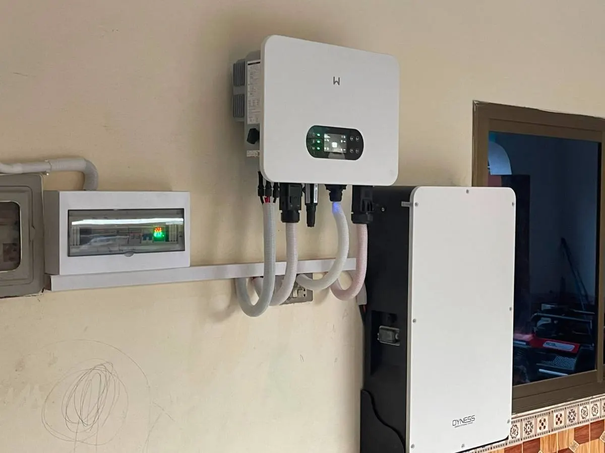 Hybrid inverter beside a tall lithium battery cabinet and an isolator in a house